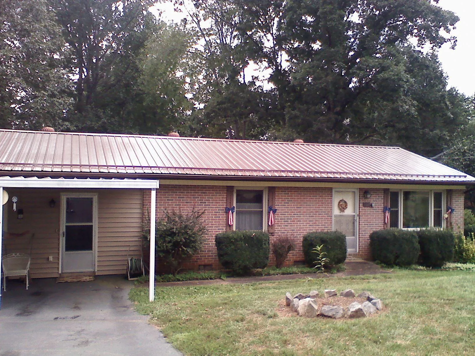 Bronze metal roof and carport on a brick ranch home — Roof Repair work by our crew in Bremen